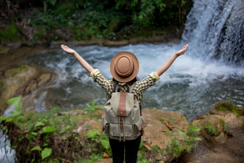 girl traveler before a waterfall