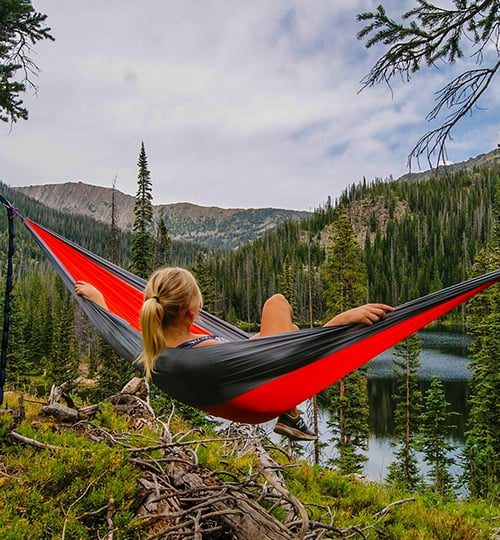 camping tourism- a girl swinging against beautiful scenery